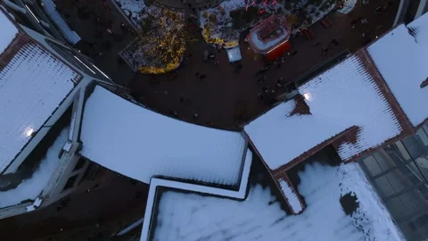 Low Aerial Flight Through Snow-Covered Outlet Mall Courtyard at Dusk Stock Footage 344925619