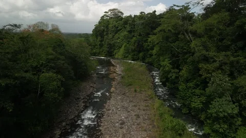 Low aerial fly forward over River Barranca river in Costa Rica on cloudy day Stock Footage 329598703