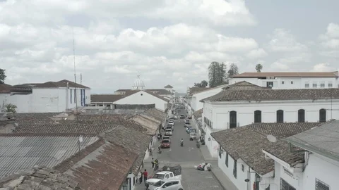 Low aerial passes over rooftops of colonial Popayan before rising up over plaza Stock-Footage 105470019