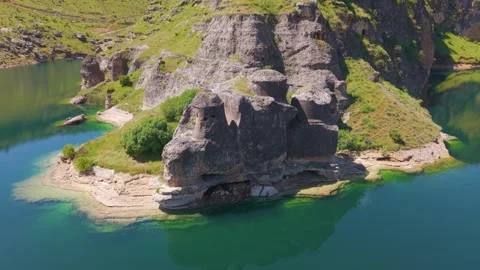 Low Aerial Pullback from Mysterious Stone Towers in a Turquoise Lake Stock Footage 340974331