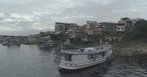 Low aerial rising up over painted wooden river boat on the Amazon River to dense 스톡 동영상 101291153
