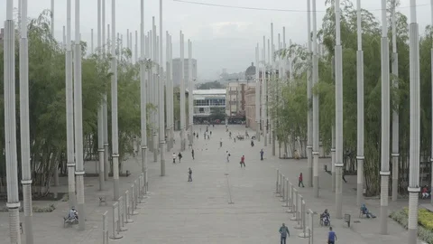 Low aerial sails through the lampposts of Parque Cisneros in Medellin, Colombia Vídeos de archivo 106176029