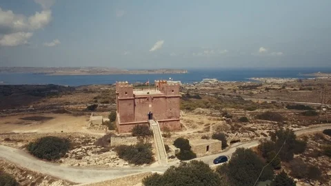 Low Aerial shot rotating around St Agatha's Red Tower in Mellieha Malta Stock Footage 90633588