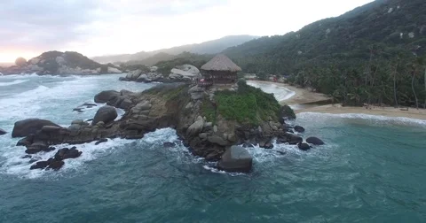 Low aerial spin around the Cabo San Juan del Guia beach campsite in Tayrona Vídeos de archivo 72474329
