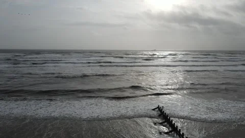 Low aerial view of Aberdeen Beach with waves, seabirds and distant ship Stock Footage 338068259