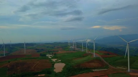 Low aerial view of cluster of wind turbines in green hillside,Thailand Video stock 79876497