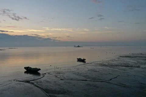 Low Aerial View of Tidal Flat and Boats at Dawn Stock Photos