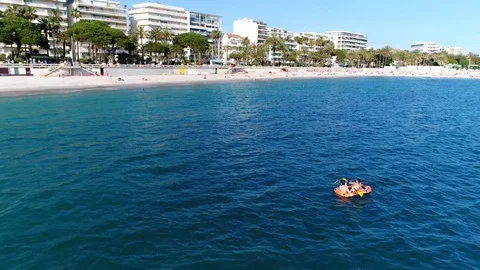 Low altitude aerial view of two kids in inflatable boat having fun 4k Stock Footage 109400744