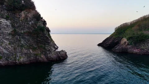 Low Altitude Backward Drone Flight Between Two Islands Near Sea Surface Stock Footage 334240185