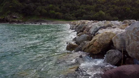 Low altitude drone flight along rocky island cliffs Stock Footage 322997537
