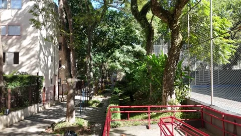 Low-altitude drone flight moving backward over a beautiful condominium garden Vídeo Stock 342788612