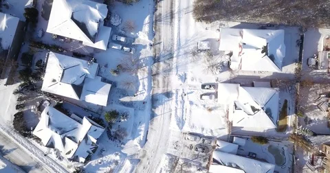 Low altitude drone flight over a snowy suburban neighborhood. Video stock 83764442