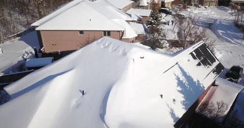 Low altitude drone flight over a snowy suburban neighborhood. Видео 83765154