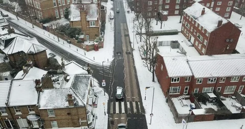 Low altitude drone flight over a road in South London, England in a snowstorm. Video stock 87168591
