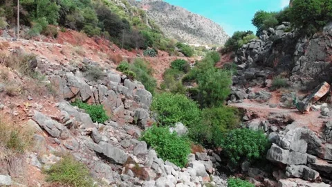 Low-Altitude Drone Flight Over Rocky Mountain with Village in the Distance Stock Footage 313659903