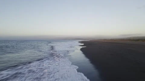 Low altitude drone flight over the shoreline where the ocean meets dark 動画素材 331683099