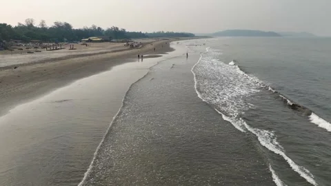 Low altitude drone flight over gentle ocean waves along a North Goa beach. Video stock 339549571