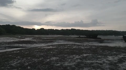 Low-Altitude Drone Flying Over River Toward Shipwrecks at Sunrise, Morbihan Stock Footage 302565749