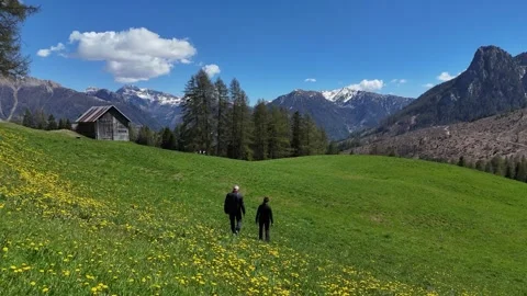 Low Altitude Drone Push Past Alpine Cabin Revealing Couple Walking in Me Stock Footage 339047334