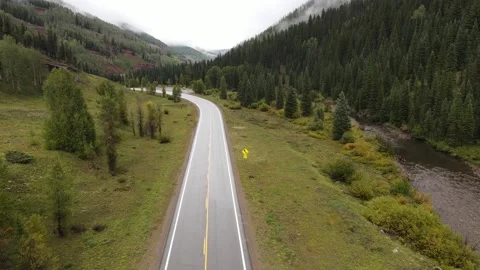 Low altitude drone shot flying over wet mountain highway Stock Footage 336504732
