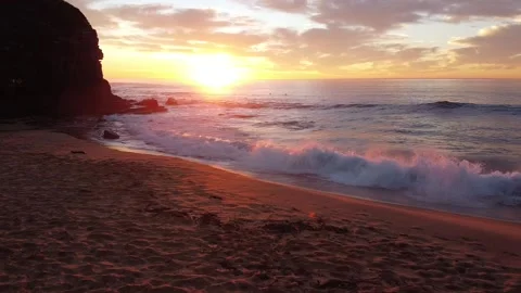 Low altitude drone shot of waves crashing on the beach at sunrise Video stock 152492218