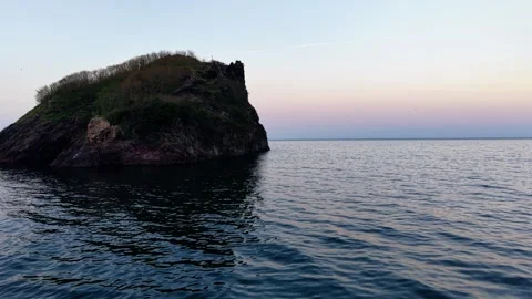 Low-Altitude Drone Tracking Shot Over Sea Towards Rocky Island Video stock 334247923