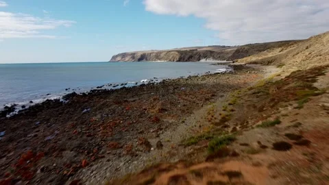Low-Altitude Drone View of Coastal Wind Turbines and Rugged Shoreline Stock Footage 308207409