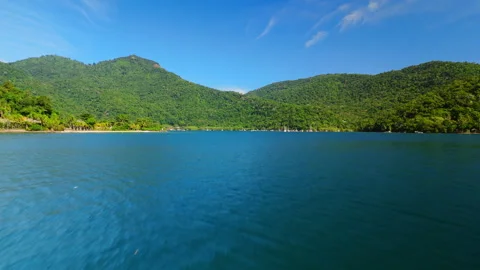 Low altitude fast flight over the sea surface with mountains on the background Stock Footage 334908882