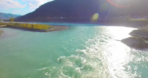 Low altitude flight over fresh fast mountain river with rocks at sunny summer Stock Footage 310717232