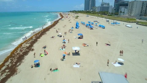Low altitude flight over tourists on Miami Beach with aerial drone Stock Footage
