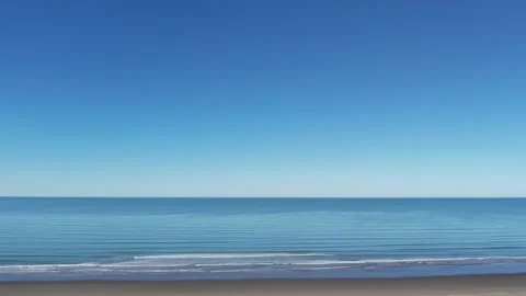 Low altitude, parallel aerial as small incoming waves roll in from Stock-Footage 286129186