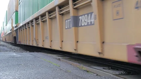 LOW AND CLOSE VIEW TRAIN CROSSING THE ROAD Video stock 81645870