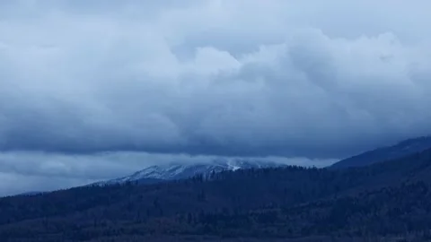 Low and gray-blue clouds moving over the snowy Skrzyczne mountain Stock Footage 132798623