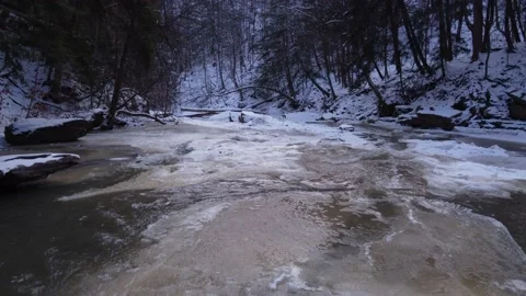 Low and slow over frozen river in a ravine Stock Footage 228475737