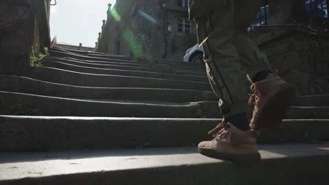 Low-angle action shot focusing on the legs and boots of a person climbing a set 動画素材 344209701