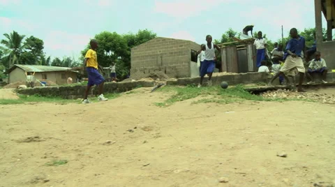 LOW ANGLE: ADEISO STUDENTS PLAYING SOCCER (SCHOOL IN BG) Stock Footage 58070236