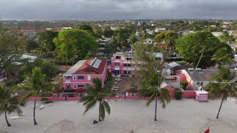 Low angle aerial drone view tracking past colorful beachfront resort hotels and Stock-Footage 336695497