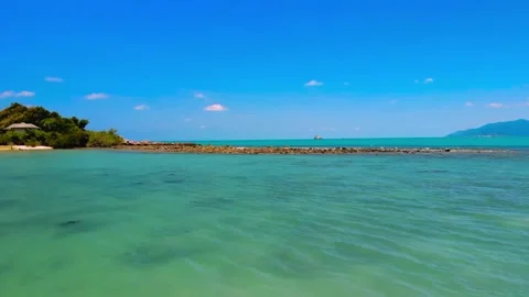 Low angle aerial drone view of crystal clear shallow sea and rocky reef 動画素材 345657015