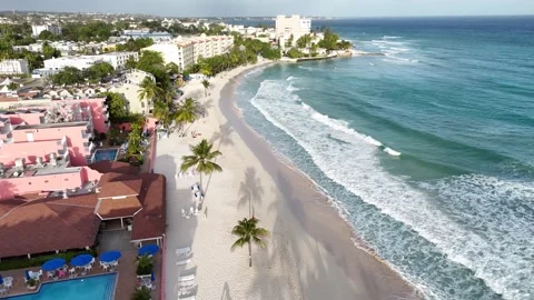 Low angle aerial flyover along the coastline of St Lawrence Gap showing ocean 動画素材 336695925