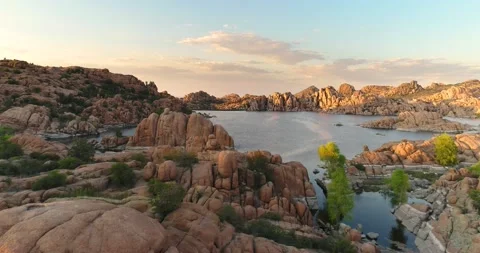 Low angle aerial view of lake with exotic granite rock formations in Arizona Stock Footage 131396104