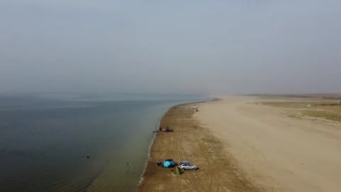 Low angle aerial view of remote campsite with tents and 4x4 car in arid steppe Stock Footage 335080247