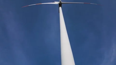 Low Angle Aerial View of Wind Turbine Tower and Blades Against Blue Sky Stock-Footage 331939352