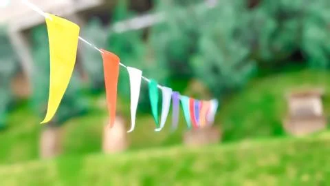 Low angle and focused view. Multicolored decorative party pennants in the park Stock Photos