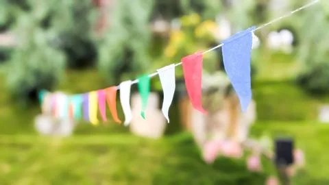 Low angle and focused view. Multicolored decorative party pennants in the park. Stock Photos
