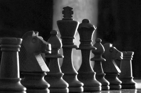 Low angle and very close up capture of white chess pieces  in low light. Sele Stock Photos