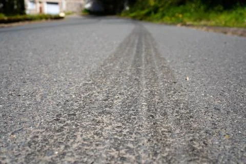 Low angle asphalt road texture with tire marks and shallow depth of field Stock Photos