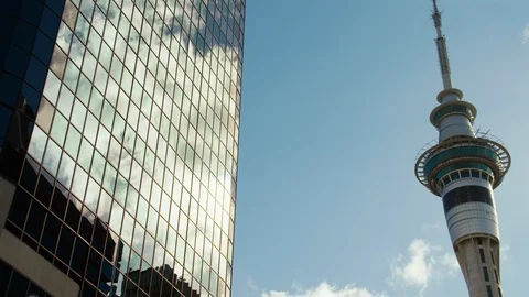 Low angle Auckland Sky Tower next to reflective glass building. Stock Footage 90343691