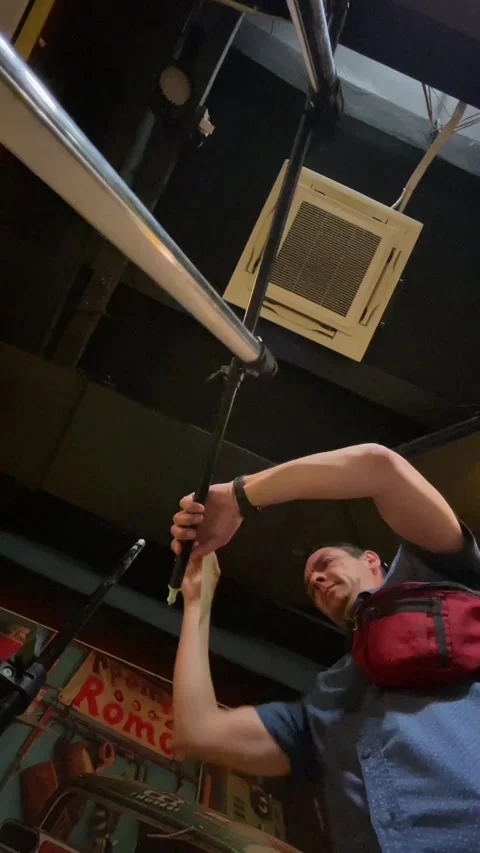 Low-angle backstage scene of technician adjusting microphone boom beneath Vidéo 344584580