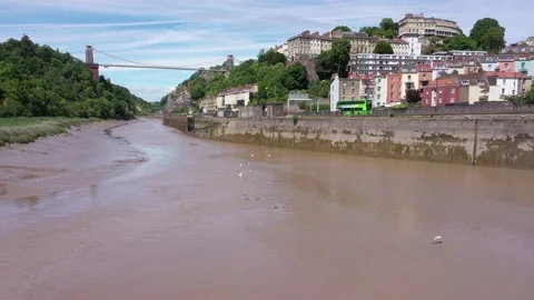 Low angle backwards aerial along River Avon with seagulls passing and Clifton Vídeos de archivo 144754583