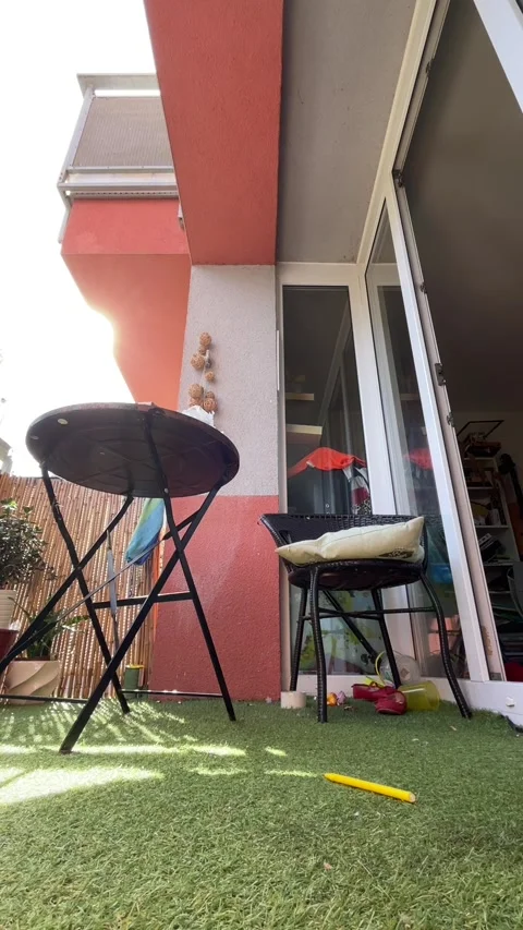 Low-angle balcony scene with toys on artificial grass and outdoor furniture Stock Footage 344883795